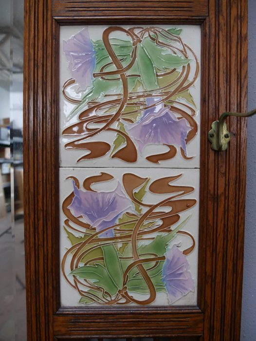 Weitere Detailaufnahme einer originalen dekorativen Jugendstil-Keramikfliese mit floralem Motiv. Die Aufnahme zeigt die feine Glasur und die farbenfrohe Gestaltung der historischen Fliese.