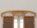 Detailaufnahme des oberen Bereichs mit geschwungenem Jugendstil-Aufsatz, großem Facettenspiegel sowie den seitlichen Garderobenhaken. Die elegante Linienführung prägt das repräsentative Erscheinungsbild der Garderobe.
