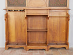 Geöffneter Unterbau der außergewöhnlichen Jugendstil-Wandgarderobe um 1900 mit beiden geöffneten Schranktüren. Sichtbar sind die geräumigen Innenfächer, das mittlere offene Ablagefach sowie die massive Holzkonstruktion. Die Aufnahme dokumentiert die funktionale Innenaufteilung und die hochwertige handwerkliche Verarbeitung der unrestaurierten Dresdner Einzelanfertigung mit geprägten Lederfüllungen und originaler Ausstattung.
