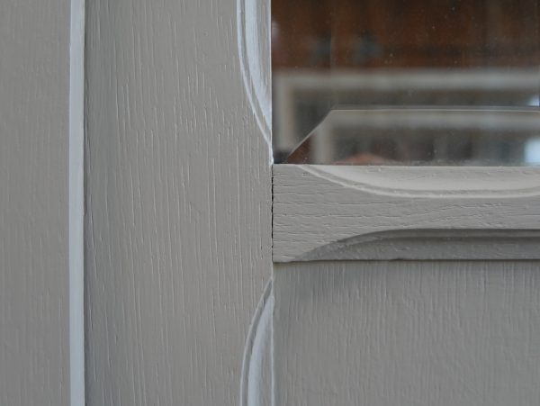 Detailaufnahme des elegant geschwungenen oberen Gesimses mit fein profilierten Leisten. Das harmonische Jugendstil-Design und die hochwertige Restaurierung betonen die elegante Formgebung des französischen Kleiderschranks.

