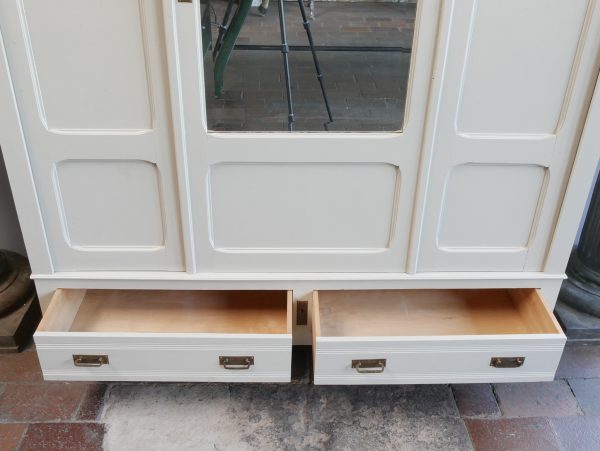 Detailaufnahme der beiden großen geöffneten Sockelschubladen des Jugendstil-Kleiderschranks. Die geräumigen Schubladen bieten zusätzlichen Stauraum und unterstreichen die hochwertige Verarbeitung des restaurierten Originalmöbels.
