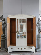 Jugendstil-Kleiderschrank mit geöffneten Seitentüren und geschlossener mittlerer Spiegeltür. Die kleinen Originalspiegel in den Außentüren sowie der große Facettenspiegel in der Mitte zeigen die raffinierte Gestaltung dieses französischen Kleiderschranks um 1900.
