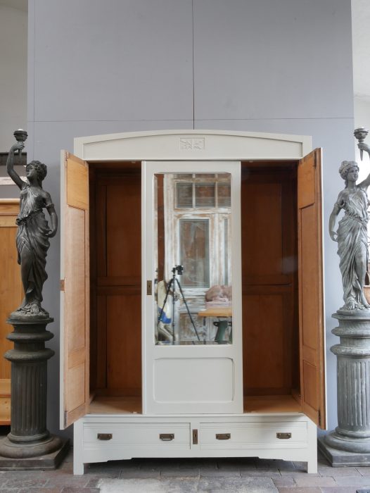 Jugendstil-Kleiderschrank mit geöffneten Seitentüren und geschlossener mittlerer Spiegeltür. Die kleinen Originalspiegel in den Außentüren sowie der große Facettenspiegel in der Mitte zeigen die raffinierte Gestaltung dieses französischen Kleiderschranks um 1900.
