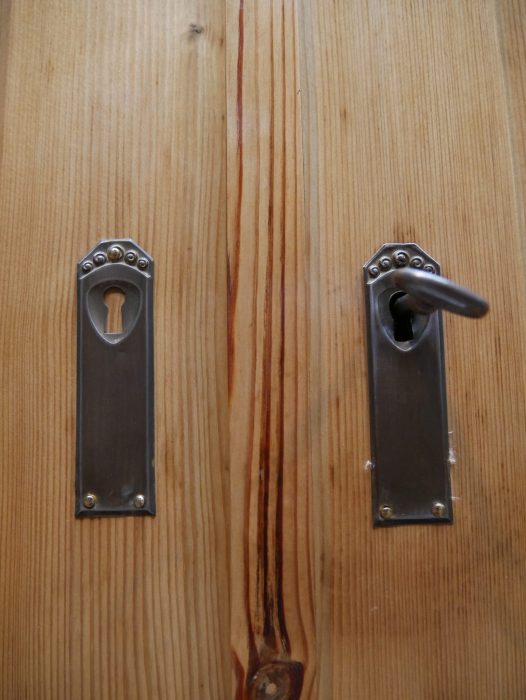 Nahaufnahme der originalen Türbeschläge des Jugendstil-Kleiderschranks. Die historischen Metallbeschläge sind vollständig erhalten und ergänzen die authentische Ausstattung des Schranks.