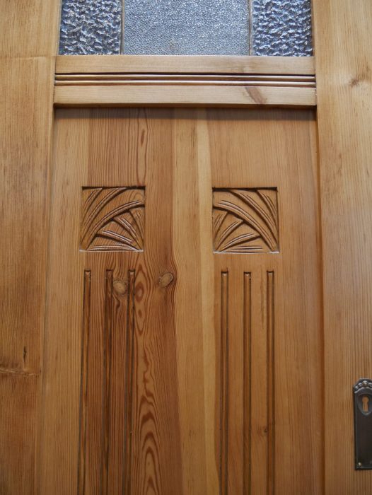 Nahaufnahme der geschnitzten Jugendstil-Ornamente auf den Türfüllungen. Die kunstvollen floralen Schnitzereien sind charakteristische Gestaltungselemente dieses originalen Jugendstil-Kleiderschranks.
