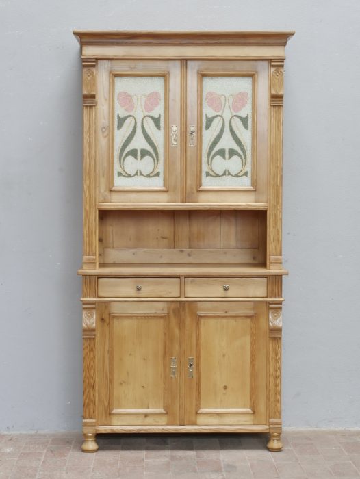 Frontalansicht des kleinen Jugendstil-Küchenbuffetts mit zweiteiligem Aufbau, dekorativen Glasscheiben, offener Ablage, Schublade und geschlossenem Unterschrank aus der Zeit um 1900.