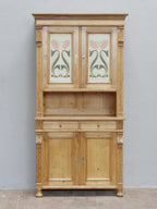 Frontalansicht des kleinen Jugendstil-Küchenbuffetts mit zweiteiligem Aufbau, dekorativen Glasscheiben, offener Ablage, Schublade und geschlossenem Unterschrank aus der Zeit um 1900.