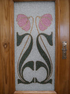 Detailaufnahme einer originalen Jugendstil-Glasscheibe mit floraler Bemalung in Schwarz, Grün und Rosa. Die kunstvolle Jugendstilmalerei gehört zur originalen Ausstattung des Buffets.
