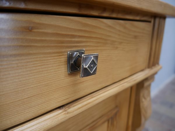 Detailaufnahme des originalen Schubladenknaufs aus Metall an der mittleren Schublade. Der historische Möbelbeschlag ergänzt die authentische Ausstattung des Buffets.