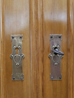Nahaufnahme der originalen Türbeschläge des Jugendstil-Küchenbuffetts. Die historischen Metallbeschläge unterstreichen den authentischen Charakter des restaurierten Möbelstücks.