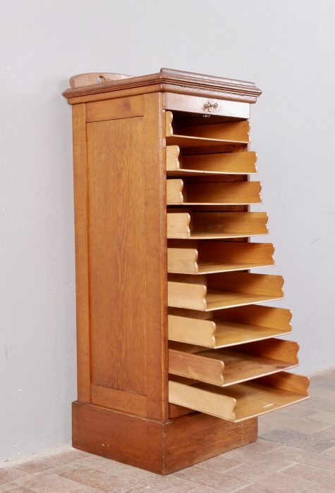 Schrägansicht des geöffneten Rollschranks mit vollständig ausgezogenem Rolladen. Die vielen Ablagefächer und die funktionale Innenaufteilung machen den seltenen Büroschrank besonders praktisch.
