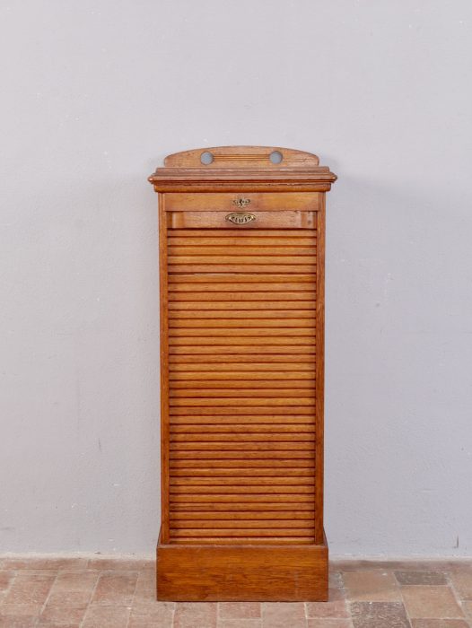 Frontalansicht des seltenen Jugendstil-Rollschranks mit vollständig geschlossener Rolllade. Gut erkennbar sind die fein gegliederten horizontalen Holzlamellen, der profilierte obere Abschluss und der massive Sockel. Die geölte Oberfläche mit altersgerechten Gebrauchsspuren bewahrt den authentischen unrestaurierten Originalzustand des historischen Stehpults.
