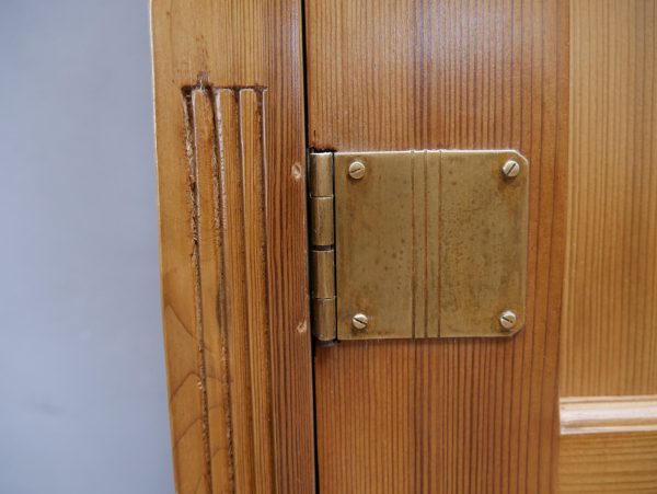 Detailaufnahme des originalen Jugendstil-Scharniers des asymmetrischen Weichholzschranks aus einer Dresdner Villa, gefertigt um 1900. Das hochwertige historische Möbelscharnier mit seiner sorgfältigen handwerklichen Ausführung und der schönen Alters-Patina unterstreicht die Originalität und den hervorragenden Erhaltungszustand des restaurierten Jugendstil-Möbels.