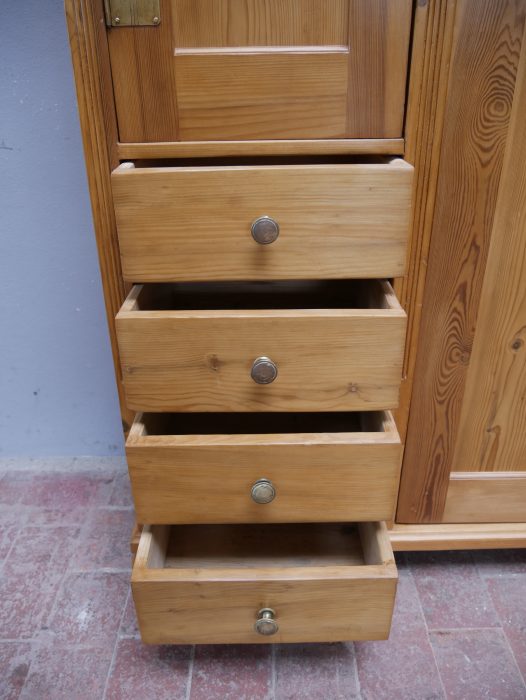 Detailansicht der geöffneten Schubkästen im schmalen linken Bereich des asymmetrischen Jugendstil-Schranks. Die Aufnahme zeigt die praktische Staffelung der einzelnen Schubladen, ihre massive Holzausführung und die außergewöhnliche Innenaufteilung der um 1900 für eine Dresdner Villa gefertigten Einzelanfertigung.