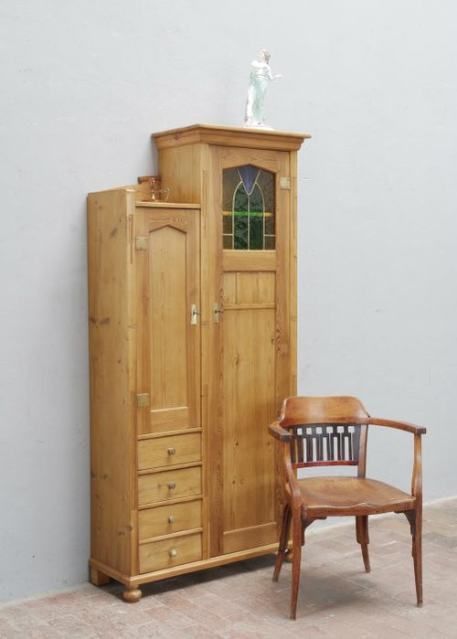 Außergewöhnlicher asymmetrischer Jugendstil-Schrank aus Weichholz, original um 1900 als Einzelanfertigung für eine Villa in Dresden gefertigt. Die Hauptansicht zeigt den wohnfertig restaurierten Schrank mit asymmetrischer Aufteilung, originalem Jugendstil-Bleiglas, originalen Beschlägen und gewachster Oberfläche.
