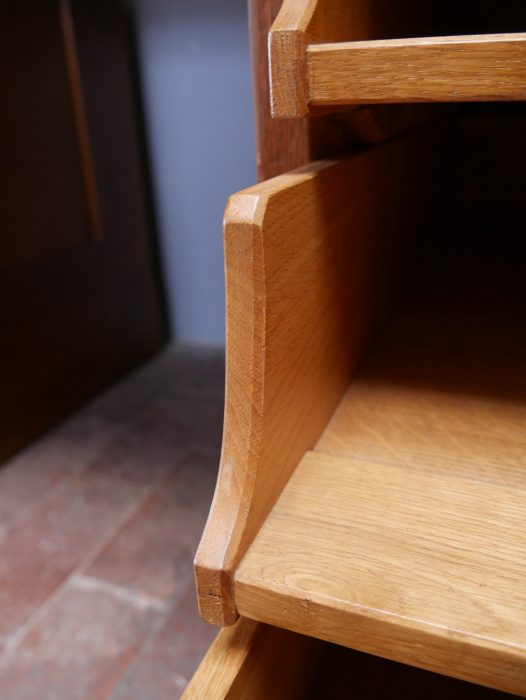 Detailaufnahme des linken Schrankfaches mit geöffneter Tür. Sichtbar sind der massive Innenraum aus Eiche sowie der originale Einlegeboden.