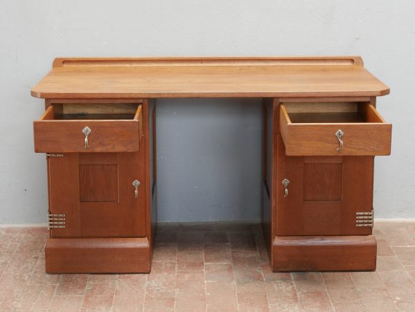Frontalansicht des originalen Jugendstil-Schreibtisches nach Richard Riemerschmid mit beiden herausgezogenen oberen Schubkästen. Die unteren Schranktüren sind geschlossen. Gut erkennbar sind die funktionale Aufteilung, die sachliche Gestaltung aus Eiche und die seltenen vernickelten Originalbeschläge der Dresdner Werkstätten Hellerau.