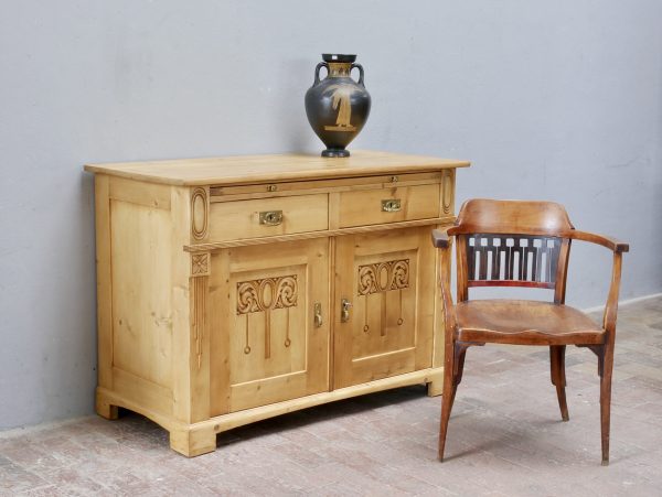 Originales Jugendstil-Sideboard beziehungsweise Anrichte aus Weichholz um 1900 in wohnfertig restauriertem Zustand. Das historische Möbel überzeugt mit schöner gewachster Oberfläche, originalen Beschlägen, dekorativen Jugendstil-Schnitzereien sowie einer großzügigen Ablageplatte und eignet sich ideal als Kommode oder Anrichte.