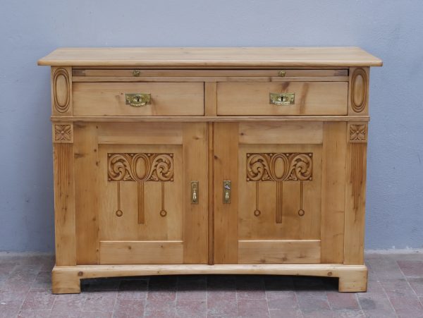 Frontansicht des historischen Jugendstil-Sideboards mit zwei Schubladen, zwei Türen und dekorativen Schnitzereien. Die originale Holzstruktur und die ausgewogenen Proportionen verleihen dem Möbel seinen besonderen Charakter.