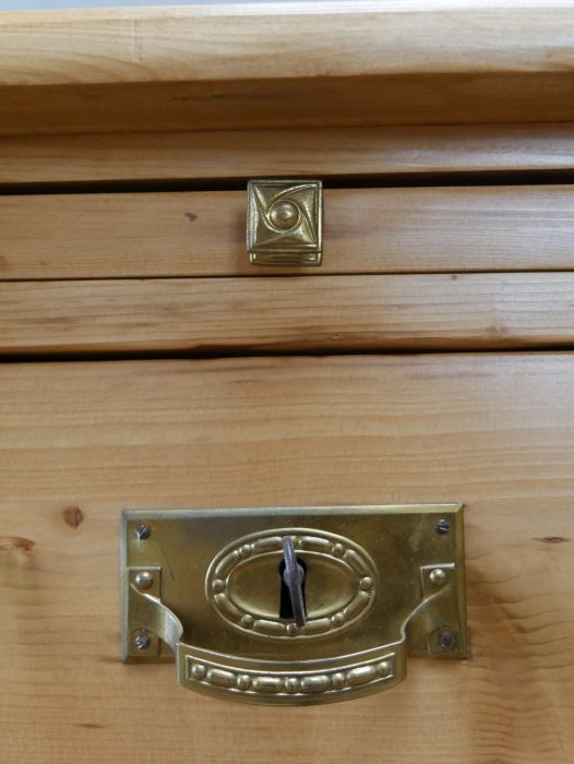 Nahaufnahme eines originalen Schubladenbeschlags aus Metall. Das historische Möbel besitzt seine zeittypischen Originalbeschläge, die den authentischen Charakter der Anrichte unterstreichen.
