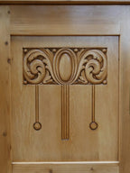 Nahaufnahme der originalen geschnitzten Türfüllung mit typischen Jugendstil-Ornamenten. Die kunstvolle Holzschnitzerei verleiht der Anrichte ihren unverwechselbaren historischen Charakter.