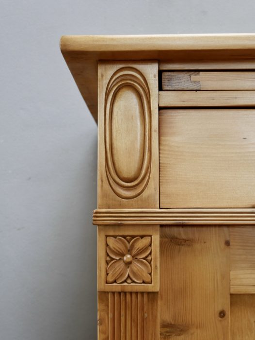 Detailaufnahme der seitlichen Profilierung mit dekorativen Jugendstil-Ornamenten und sorgfältig ausgearbeiteten Holzelementen. Die feinen Verzierungen unterstreichen den eleganten Stil des historischen Möbels.
