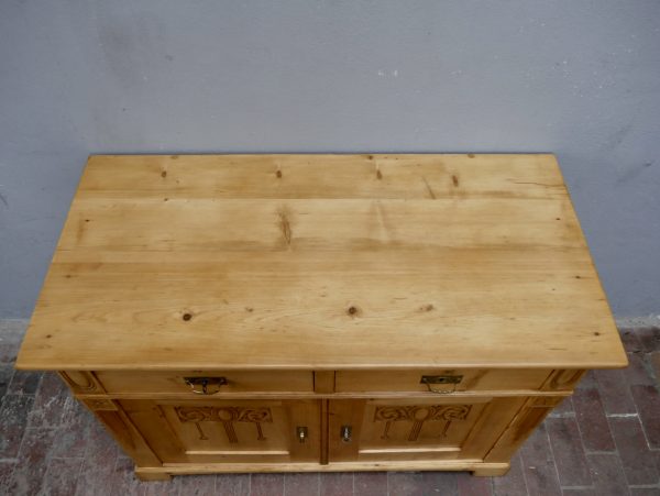 Detailaufnahme der gewachsten Weichholzoberfläche mit natürlicher Holzmaserung und wohnfertig restaurierter Oberfläche. Die Aufnahme zeigt die hochwertige Materialqualität des historischen Jugendstil-Möbels.