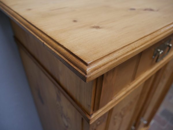 Detailaufnahme der oberen Deckplatte mit gewachster Weichholzoberfläche und schöner natürlicher Holzmaserung. Die Aufnahme zeigt den wohnfertig restaurierten Zustand des historischen Möbels.