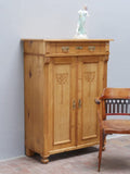 Bezauberndes originales Jugendstil-Vertiko aus Weichholz um 1890 in wohnfertig restauriertem Zustand. Das historische Möbel besitzt aufwendig geschnitzte Jugendstil-Ornamente, einen Schubkasten, drei Einlegeböden sowie originale Beschläge und überzeugt durch seine warme, gewachste Holzoberfläche.