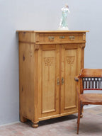 Bezauberndes originales Jugendstil-Vertiko aus Weichholz um 1890 in wohnfertig restauriertem Zustand. Das historische Möbel besitzt aufwendig geschnitzte Jugendstil-Ornamente, einen Schubkasten, drei Einlegeböden sowie originale Beschläge und überzeugt durch seine warme, gewachste Holzoberfläche.