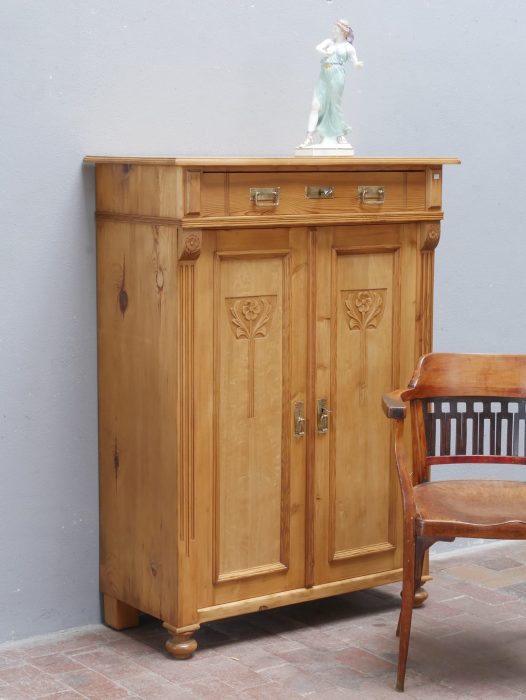 Bezauberndes originales Jugendstil-Vertiko aus Weichholz um 1890 in wohnfertig restauriertem Zustand. Das historische Möbel besitzt aufwendig geschnitzte Jugendstil-Ornamente, einen Schubkasten, drei Einlegeböden sowie originale Beschläge und überzeugt durch seine warme, gewachste Holzoberfläche.