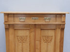 Detailaufnahme des oberen Schubkastenbereichs mit originalen Beschlägen. Die sorgfältige Verarbeitung und die natürliche Weichholzoberfläche unterstreichen den authentischen Charakter des Jugendstil-Vertikos.
