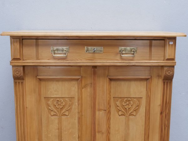 Detailaufnahme des oberen Schubkastenbereichs mit originalen Beschlägen. Die sorgfältige Verarbeitung und die natürliche Weichholzoberfläche unterstreichen den authentischen Charakter des Jugendstil-Vertikos.
