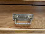 Nahaufnahme eines originalen Schubladenbeschlags aus Metall. Der historische Beschlag ist vollständig erhalten und ergänzt die authentische Ausstattung des Jugendstil-Vertikos.
