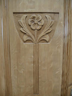 Nahaufnahme der kunstvoll geschnitzten Jugendstil-Ornamente auf der Türfüllung. Die floralen Schnitzereien sind typische Gestaltungselemente hochwertiger Jugendstil-Möbel.
