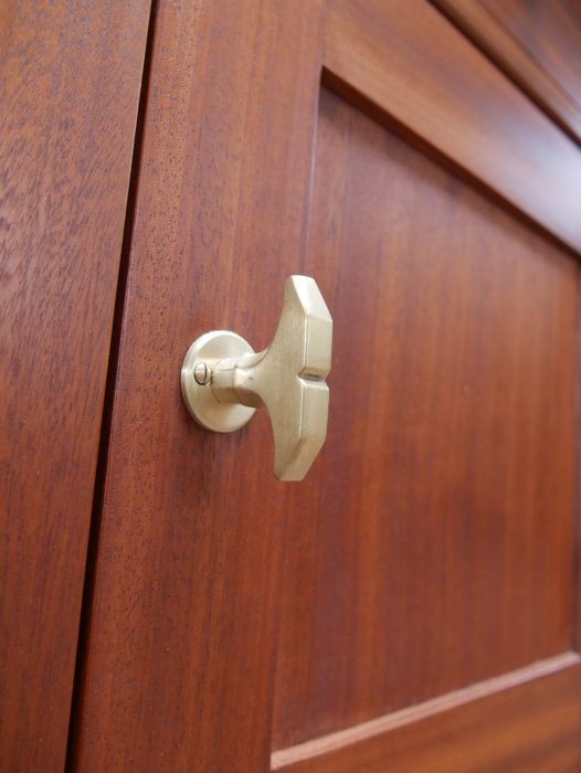 Detailaufnahme des originalen Türknopfes der historischen Waschkommode. Der originale Beschlag ergänzt die hochwertige Ausstattung des seltenen Jugendstil-Möbels.