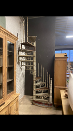 Die originale Jugendstil-Wendeltreppe nach dem Aufbau im Innenraum. Die elegante Spindeltreppe aus Gusseisen und Schmiedeeisen eignet sich als außergewöhnlicher Blickfang für historische Gebäude, Lofts oder stilvolle Wohnräume und überzeugt durch ihre originale Patina.
