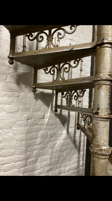Detailaufnahme der dekorativen schmiedeeisernen Geländerverzierungen der originalen Jugendstil-Wendeltreppe. Die geschwungenen Ornamente unterstreichen die hochwertige handwerkliche Ausführung um 1900.