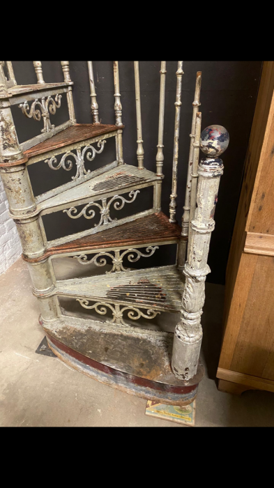 Detailansicht der gewendelten Treppenstufen entlang der Mittelsäule. Die Aufnahme zeigt den gleichmäßigen Verlauf der Stufen sowie die stabile Konstruktion aus Gusseisen und Schmiedeeisen im Originalzustand.
