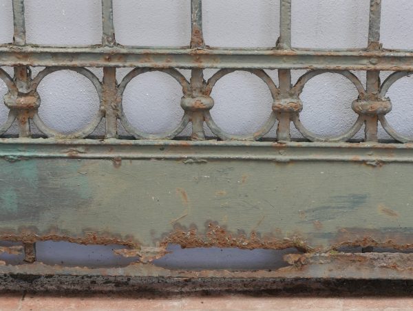 Detailaufnahme der charakteristischen ringförmigen Schmiedeeisen-Ornamente im unteren Bereich der Zaunanlage. Die dekorativen Kreise bilden ein typisches Gestaltungselement der historischen Jugendstil-Schmiedearbeit.