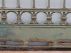Detailaufnahme der charakteristischen ringförmigen Schmiedeeisen-Ornamente im unteren Bereich der Zaunanlage. Die dekorativen Kreise bilden ein typisches Gestaltungselement der historischen Jugendstil-Schmiedearbeit.
