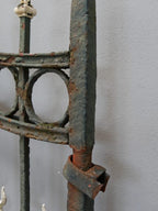 Detailaufnahme eines seitlichen Torpfostens mit angeschlossenem Zaunfeld. Die Verbindung zwischen Pfosten und Zaunelement verdeutlicht die massive Schmiedeeisenkonstruktion der historischen Zaunanlage.