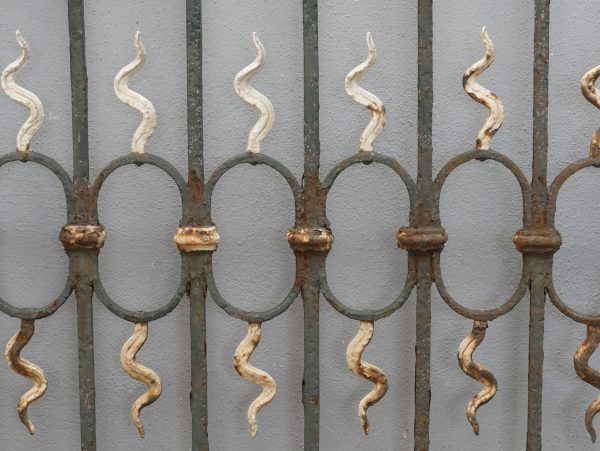 Detailansicht der geschmiedeten Zierstäbe mit dekorativen Ornamenten der historischen Zaunanlage. Die kunstvoll gearbeiteten Elemente verleihen dem Zaun seine elegante Jugendstil-Optik.