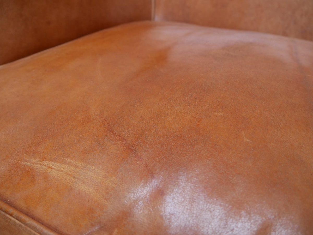 Nahaufnahme der Lederoberfläche mit charakteristischer natürlicher Patina, feinen Gebrauchsspuren und hochwertiger Schafslederstruktur. Das Detail unterstreicht den authentischen Vintage-Charakter des Sofas.
