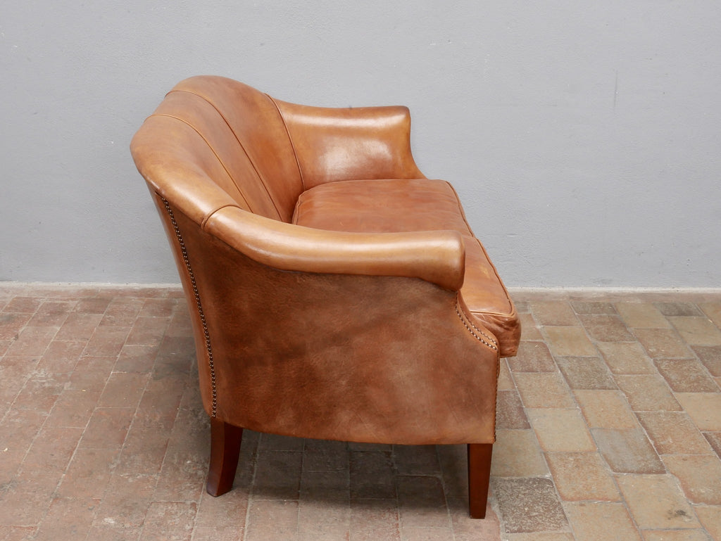Linke Seitenansicht des exklusiven niederländischen Lounge-Sofas aus Schafsleder. Gut sichtbar sind die geschwungene Armlehne, die komfortable Rückenlehne und die ausgewogenen Proportionen des hochwertigen Vintage-Möbels.
