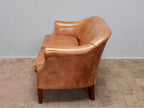 Rechte Seitenansicht des Vintage-Ledersofas aus den Niederlanden um 1970. Die elegante Linienführung, die geschwungene Rückenlehne sowie die charakteristische Patina des Schafsleders werden aus dieser Perspektive besonders deutlich.
