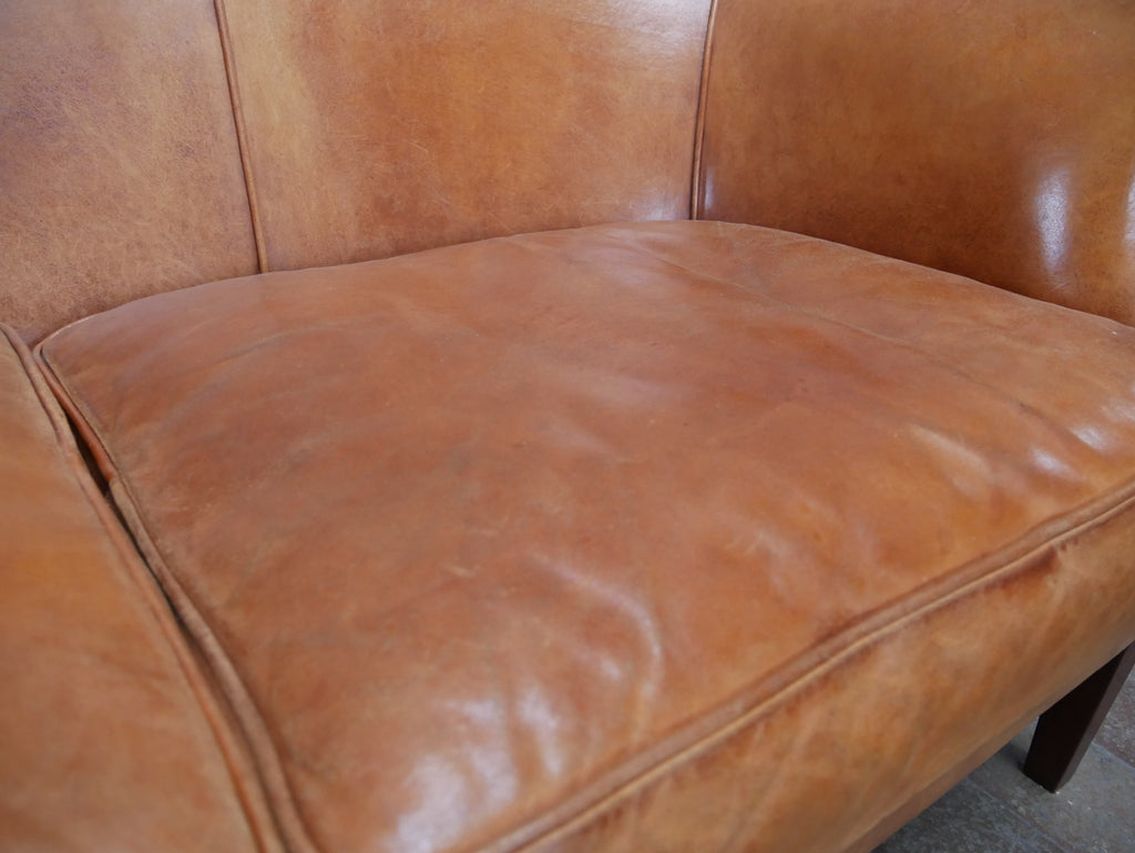 Detailaufnahme der rechten Sitzfläche des Schafsleder-Sofas. Die feine Lederstruktur, die natürliche Nutzungspatina und die weiche Polsterung verdeutlichen die hohe Qualität und den angenehmen Sitzkomfort.
