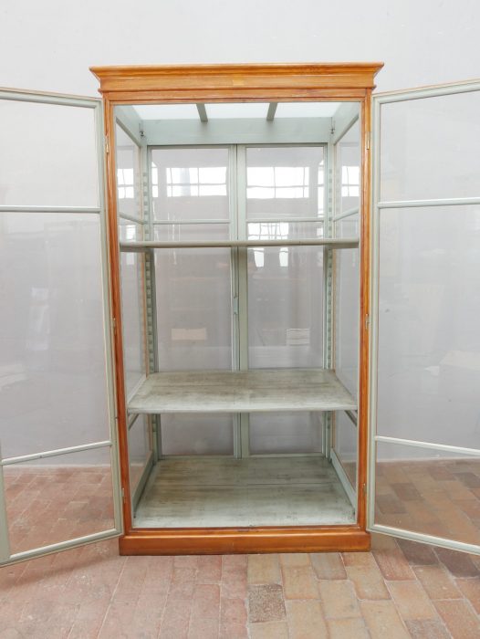 Innenansicht der historischen Vitrine mit original grau-grüner Innenfarbe und zwei höhenverstellbaren Einlegeböden. Die Konstruktion ermöglicht eine flexible Präsentation von Sammlungsstücken oder Waren.