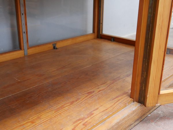Detailaufnahme des massiven Holzbodens im Innenraum der Vitrine. Die Aufnahme zeigt die hochwertige Verarbeitung und die schöne originale Patina des Weichholzes.