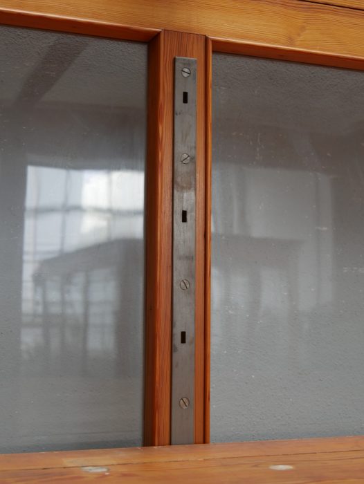Nahaufnahme der originalen Metallkonsolen zur Höhenverstellung der Einlegeböden. Die stabile Konstruktion erlaubt eine flexible Anpassung der Innenaufteilung.